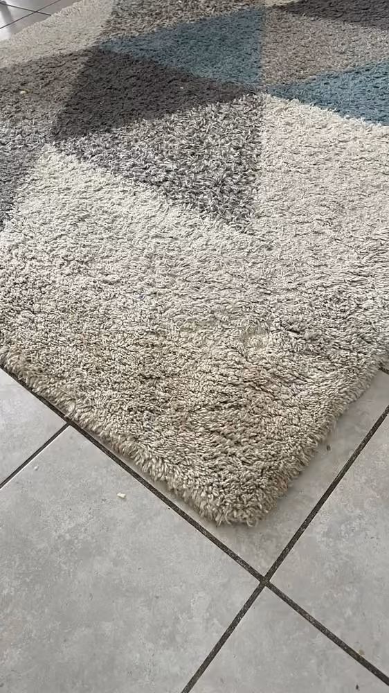 Tapis à motifs géométriques gris avant nettoyage